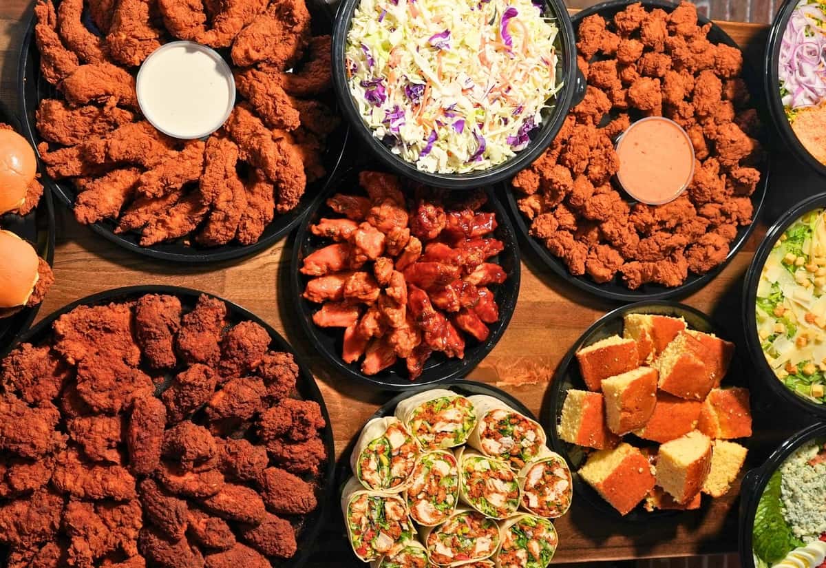 Catered trays of chicken nuggets, chicken tenders, and salads