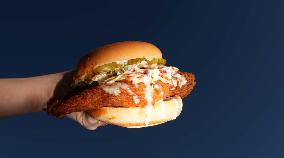 Hand holding a chicken sandwich