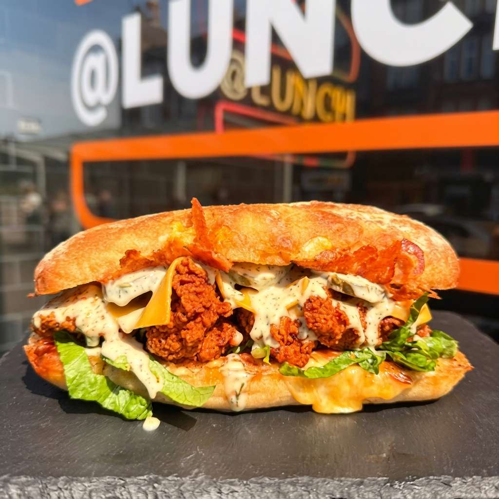@Lunch crispy fried chicken sandwich with melted cheese, lettuce, pickles, and creamy herb sauce