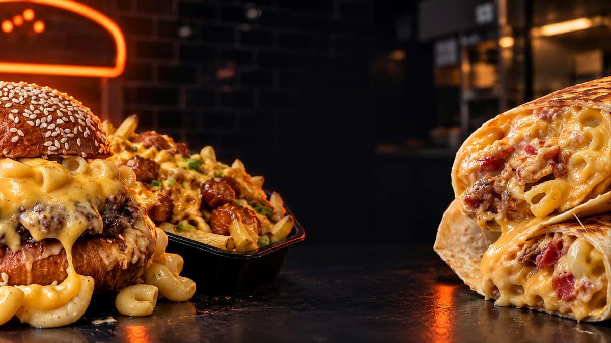 Cheesy mac and cheese burger with loaded fries and grilled mac and cheese wraps in a modern restaurant setting