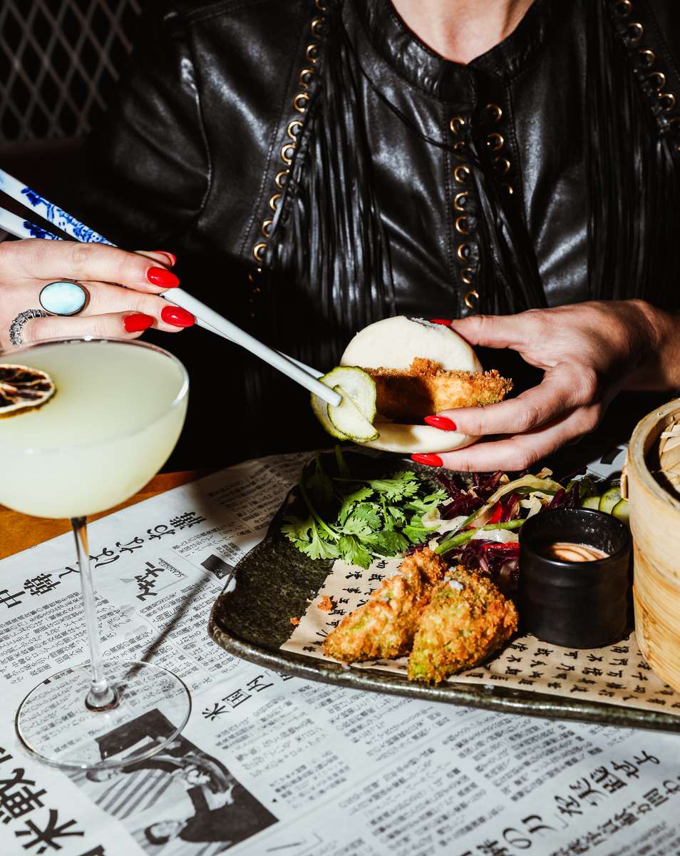 person eating bao buns and other menu items
