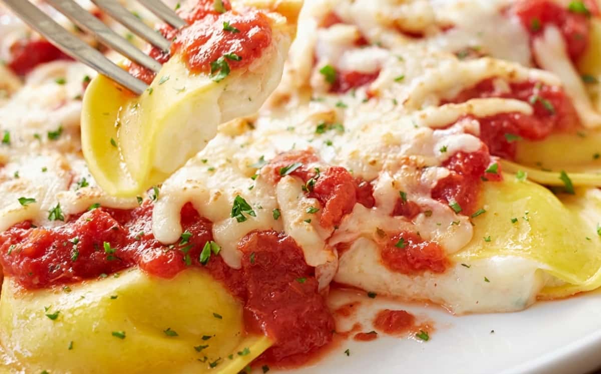 Cheese-filled ravioli topped with marinara sauce, melted cheese, and parsley.