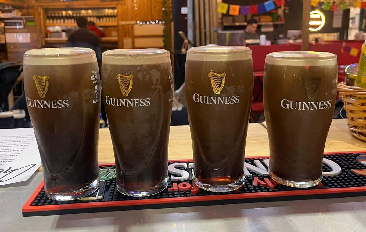 Four glasses of beer on a bar countertop