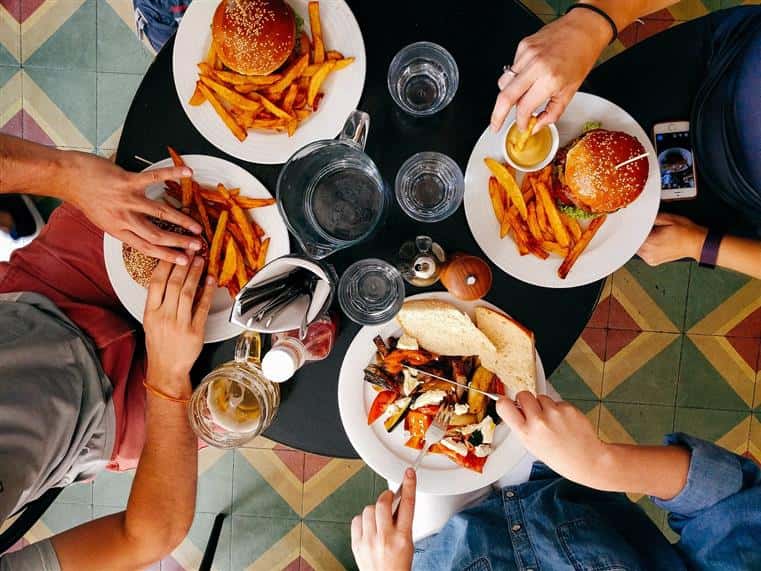 cafe seating with plates of burgers and fries