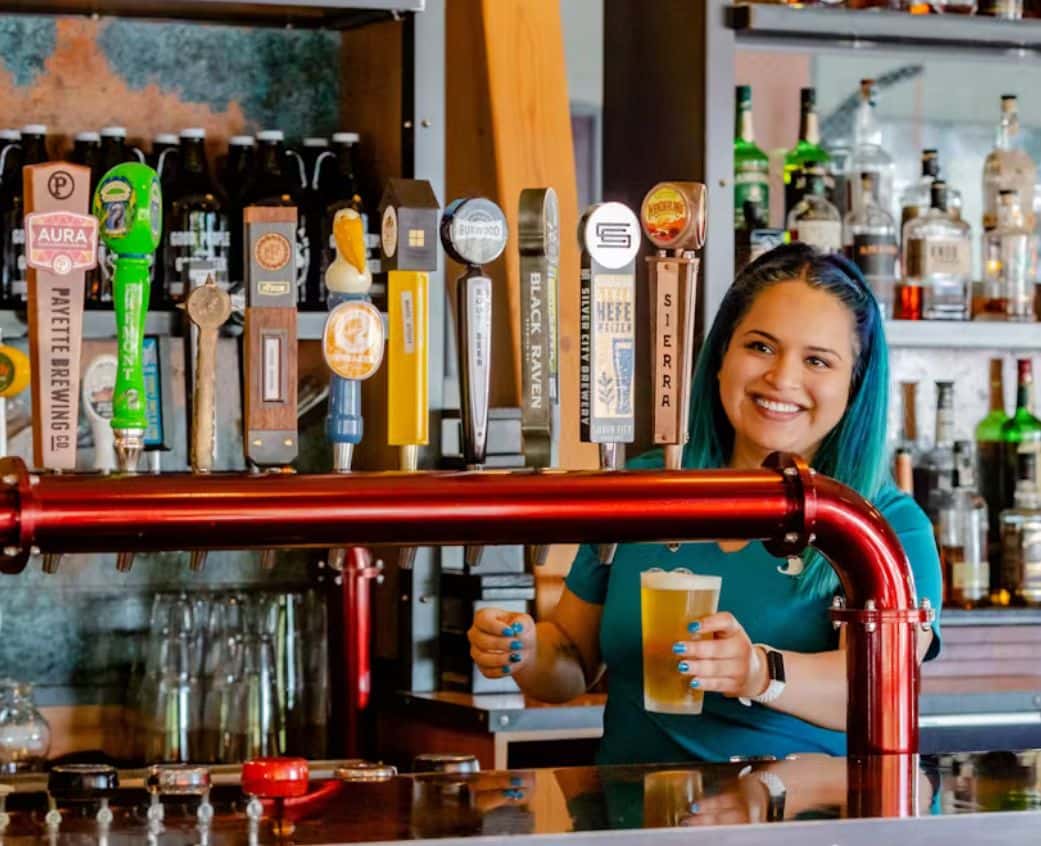Bartender smiling while holding drinks