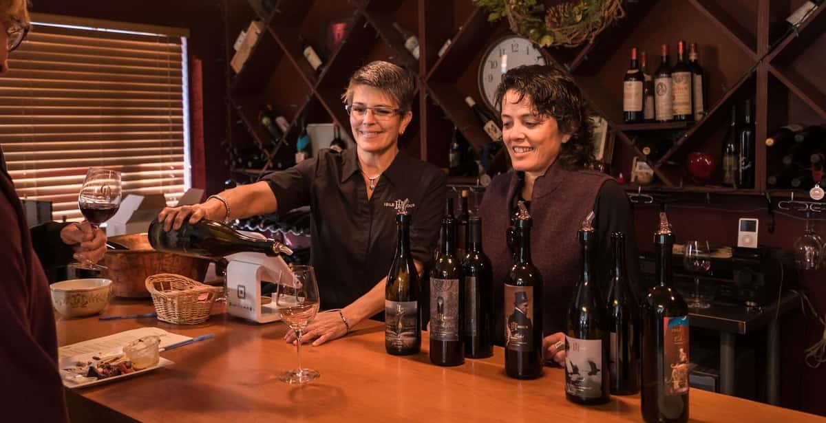 Owners Deb Payne and Anna Marie Dos Remedios pour Idle Hour's wines in the winery.