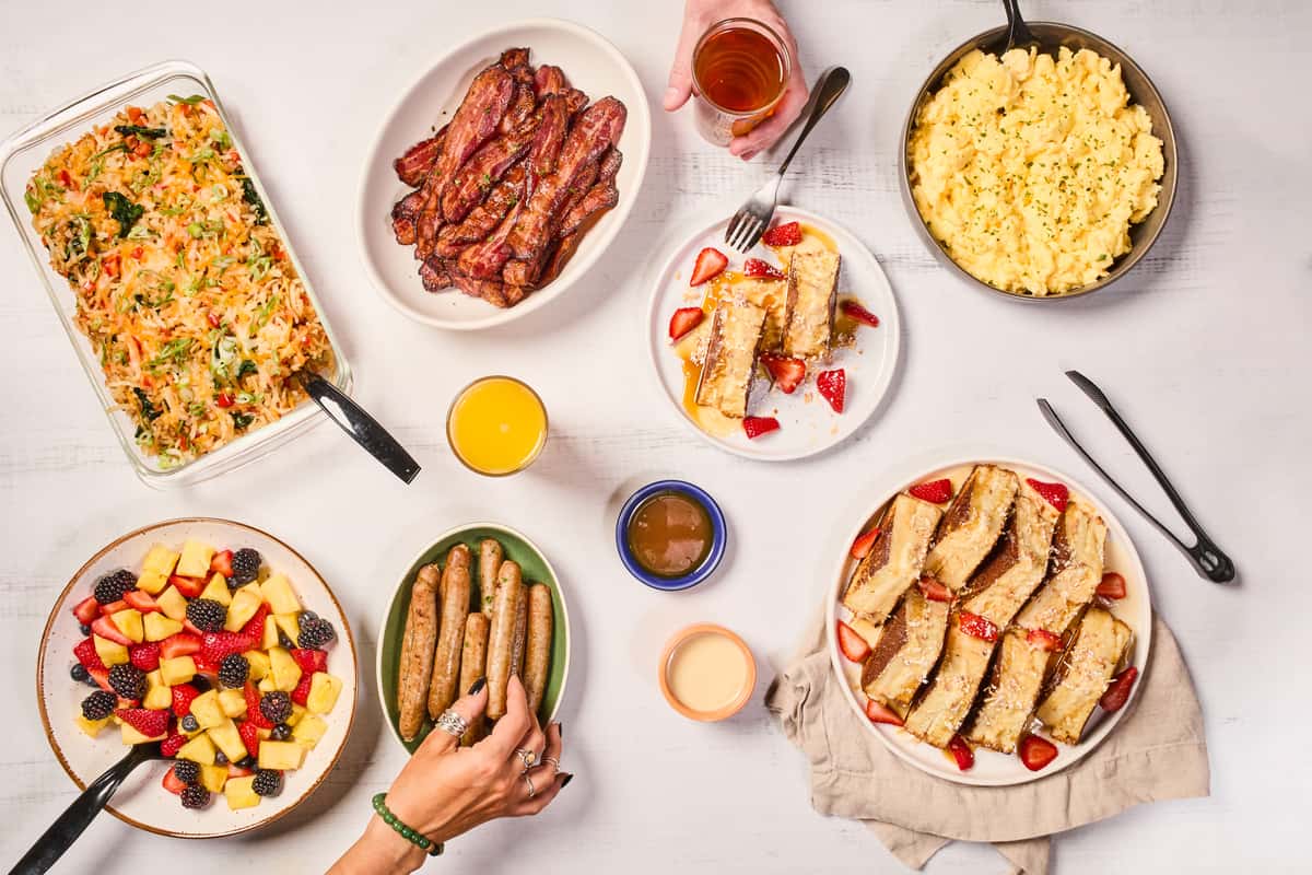 Overhead view of a Snooze breakfast catering spread with French toast, scrambled eggs, fruit and coffee
