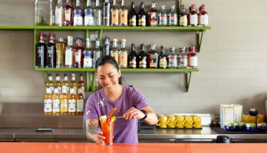 bartender behind bar making drinks