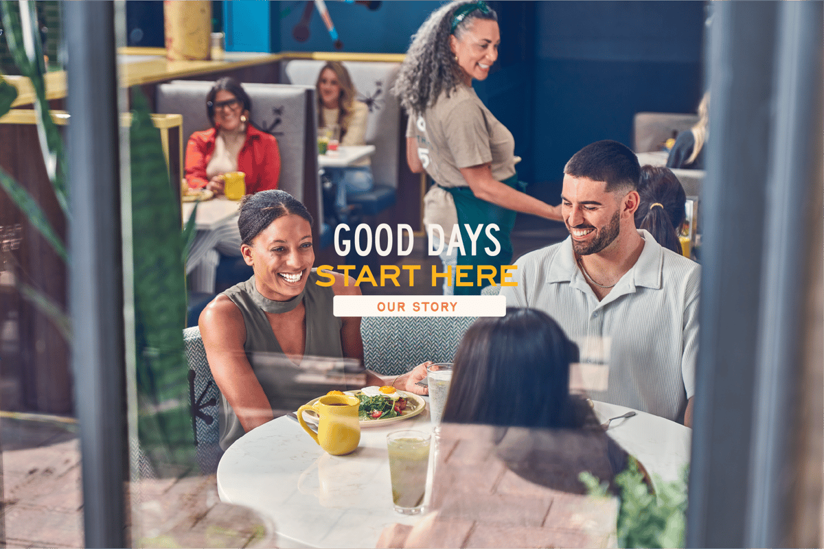 Guests smiling at a brunch table with headline 'Good Days Start Here'