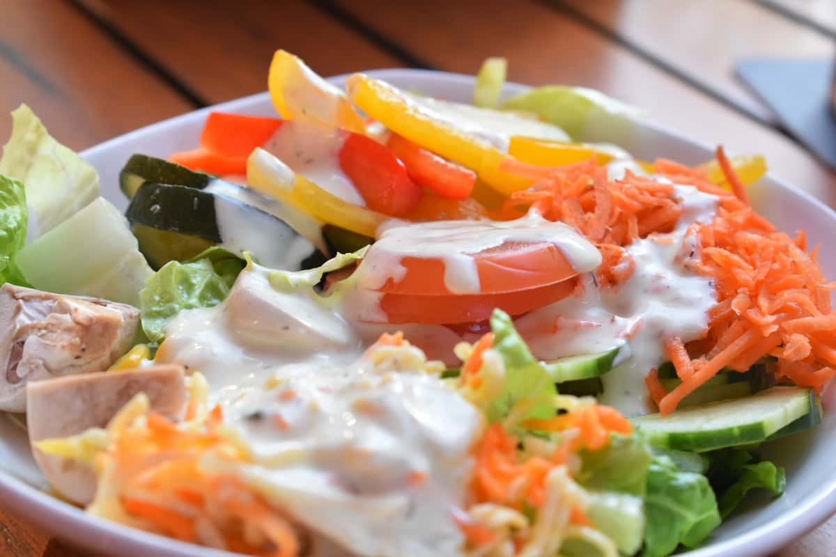 salad with carrots, cucumber, tomato, yellow peppers and dressing