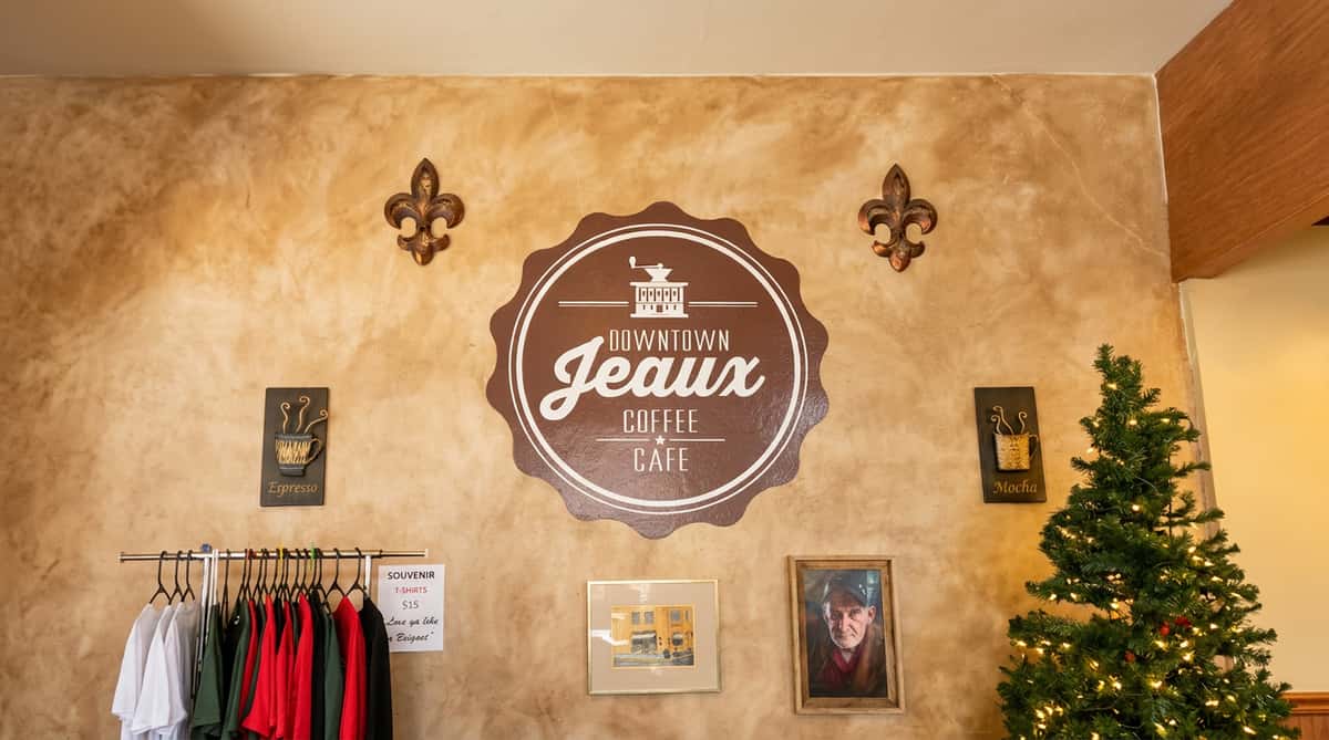 Coffee shop wall with a "Downtown Jeaux Coffee Cafe" sign, two fleur-de-lis, and "Espresso" and "Mocha" plaques.