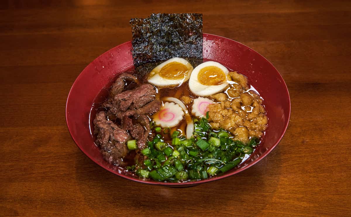 tender sliced seasoned beef on top of warm udon noodles in a sweet and savory dashi broth
