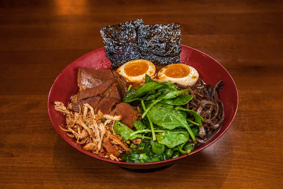 Ramen in creamy pork broth blended with spicy miso, topped with spicy shredded chicken, pork chashu, spinach, wood ear mushroom, sesame seeds, marinated egg, scallions, roasted seaweed, and chili oil