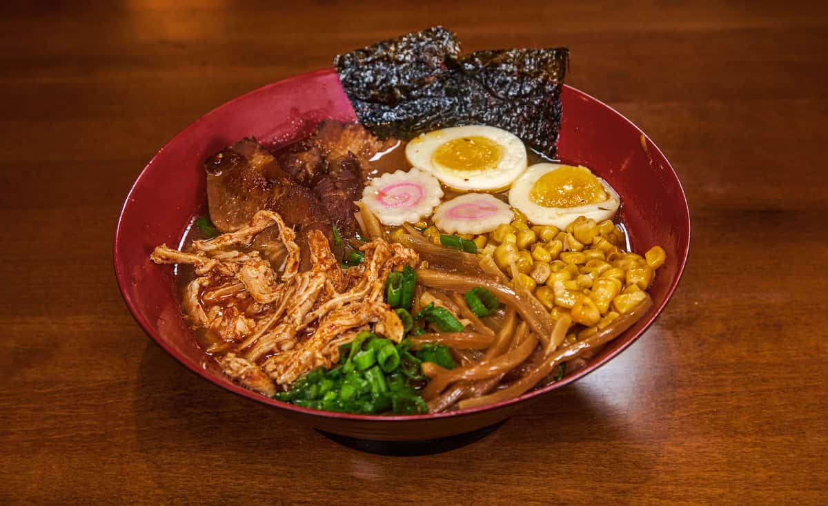 Ramen in light chicken, pork and vegetable broth blended with soy sauce flavor, topped with pork chashu, shredded chicken, narutomaki, marinated egg, menma, corn, scallion, roasted seaweed, and chili oil