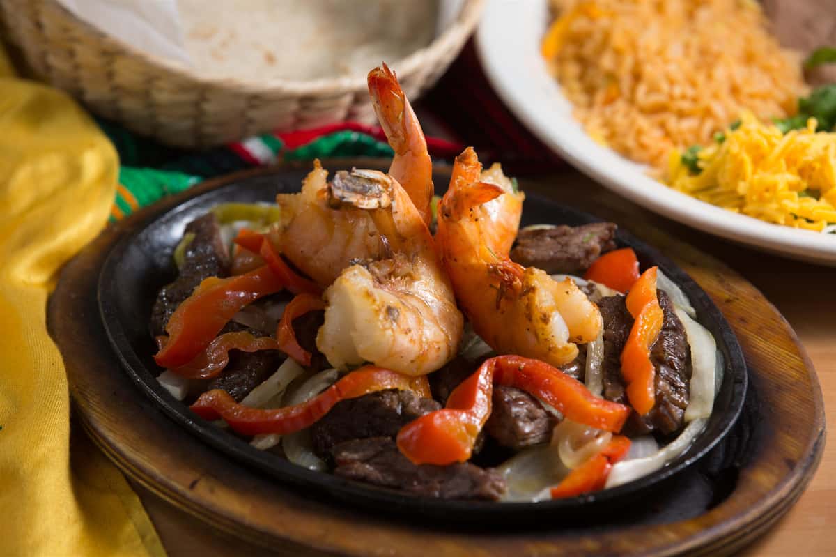 sizzling plate with shrimp, meat and red bellpeppers