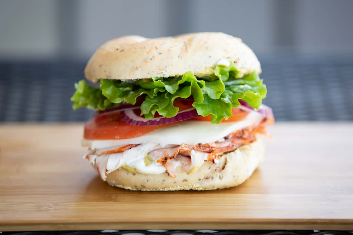 bagel sandwich with smoked salmon, lettuce, tomato, and cream cheese on a toasted bagel