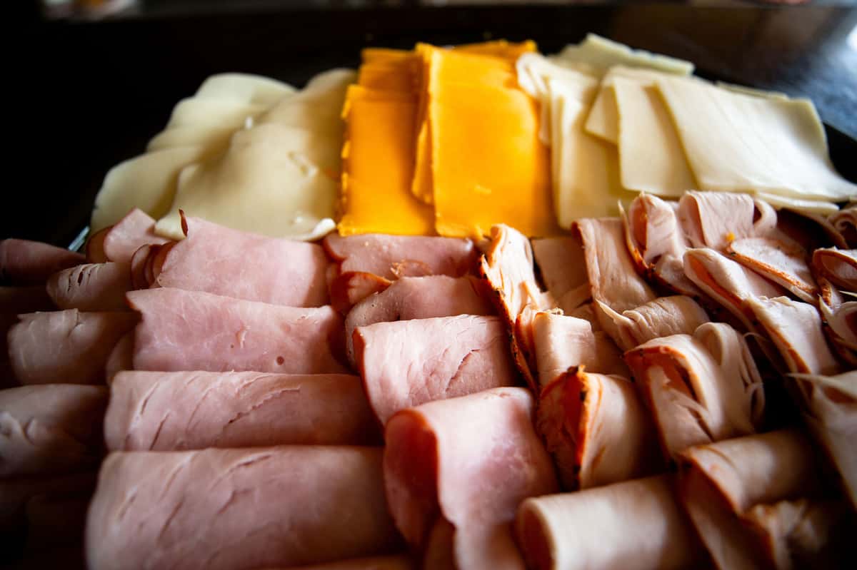 assorted deli meats and sliced cheeses arranged on a charcuterie platter