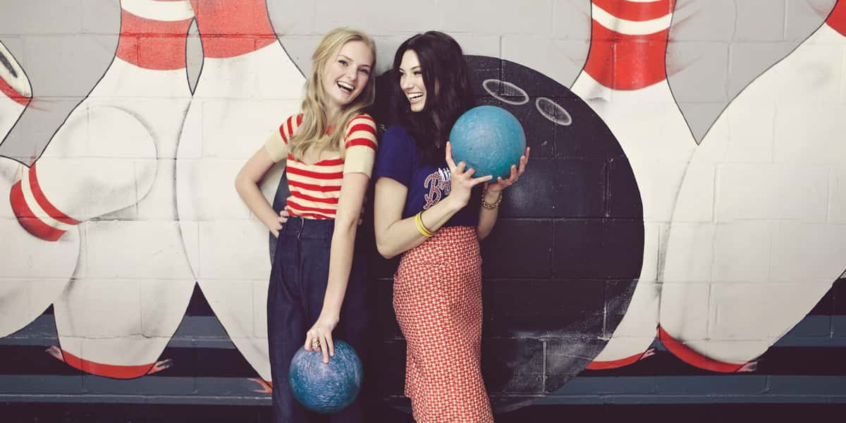 Two girls standing in front of bowling art