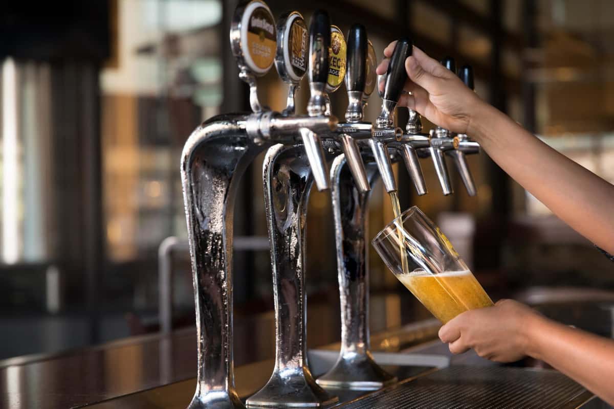 person pouring tap beer