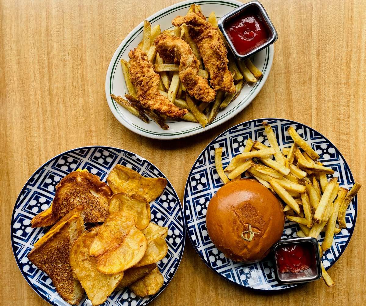Crispy chicken tenders, burger, and grilled cheese with golden fries and chips from KP's Kitchen.
