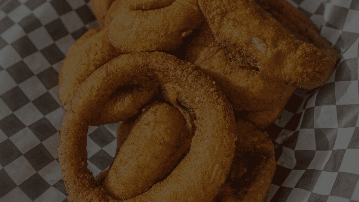 Deep-fried churros on checkered wax paper.