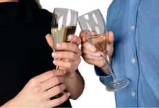 two wine glasses clicking together