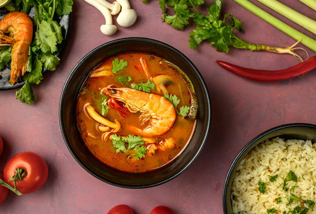 A spread of Thai meals with a display of fresh ingredients used to make them