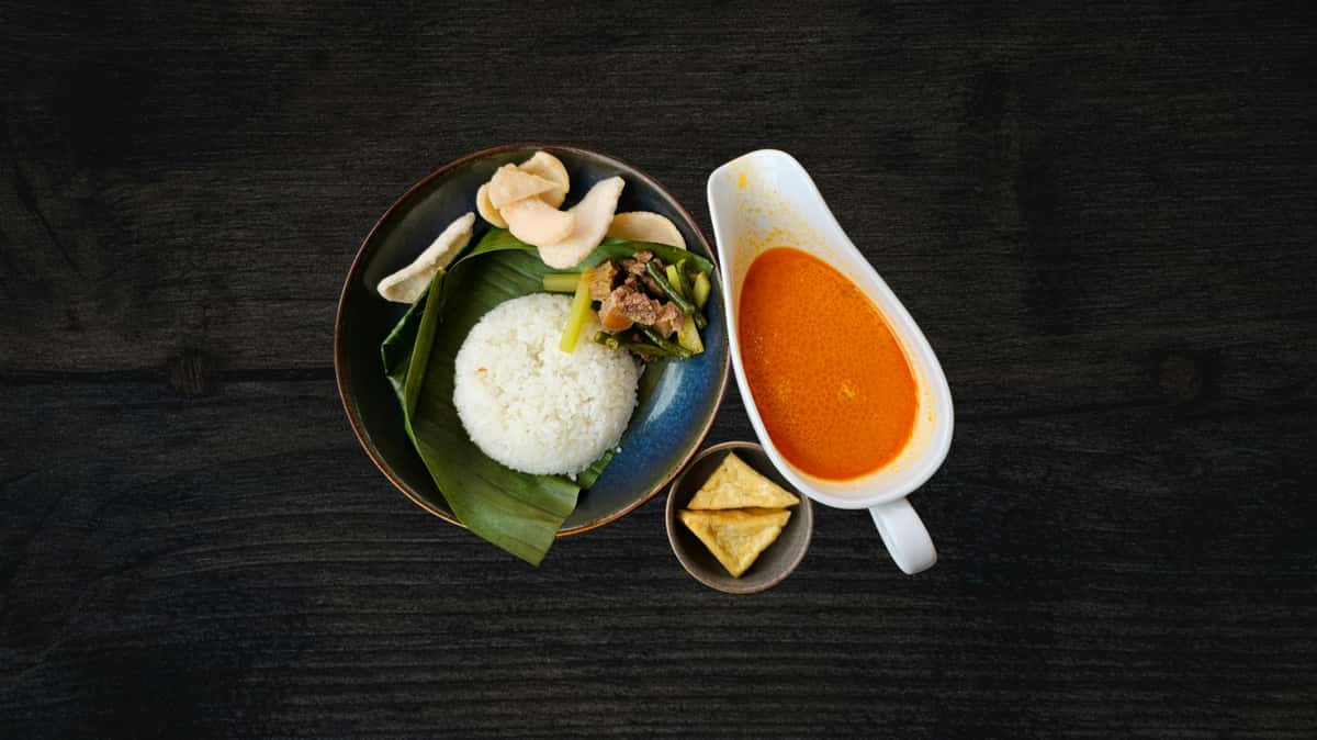 Elegantly laid out Thai meal with a side and a sauce