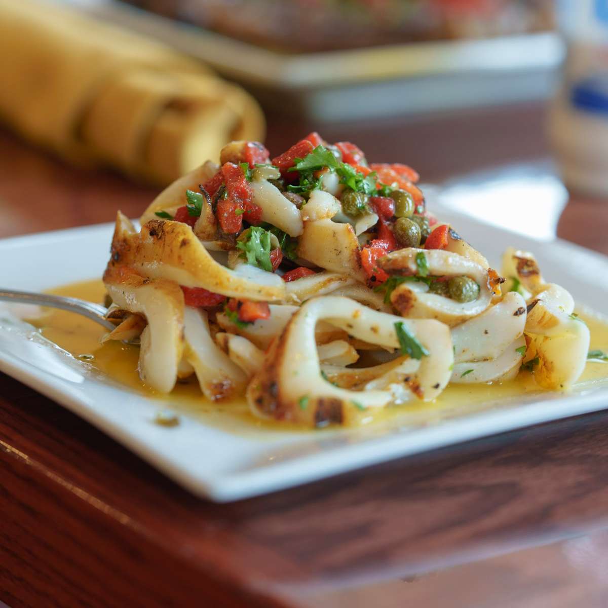 Tender charcoal-grilled calamari drizzled with olive oil and lemon.