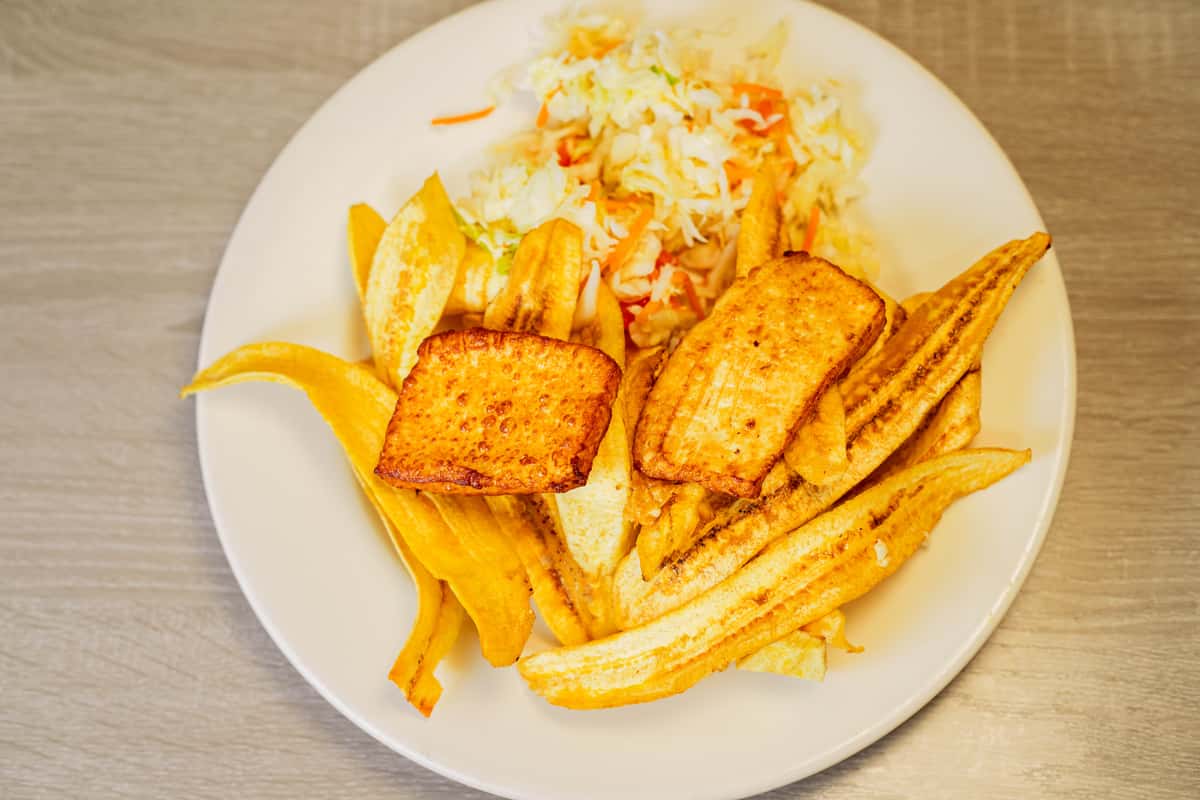 tajadas are handmade plantain chips served with cabbage salad and fried cheese.