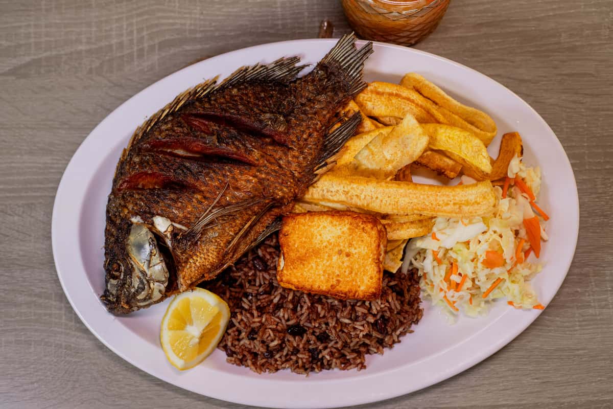 Fried Tilapia, served with Gallo pinto, Handmade Plantain chips or sweet soft plantain, fried cheese and cabbage salad