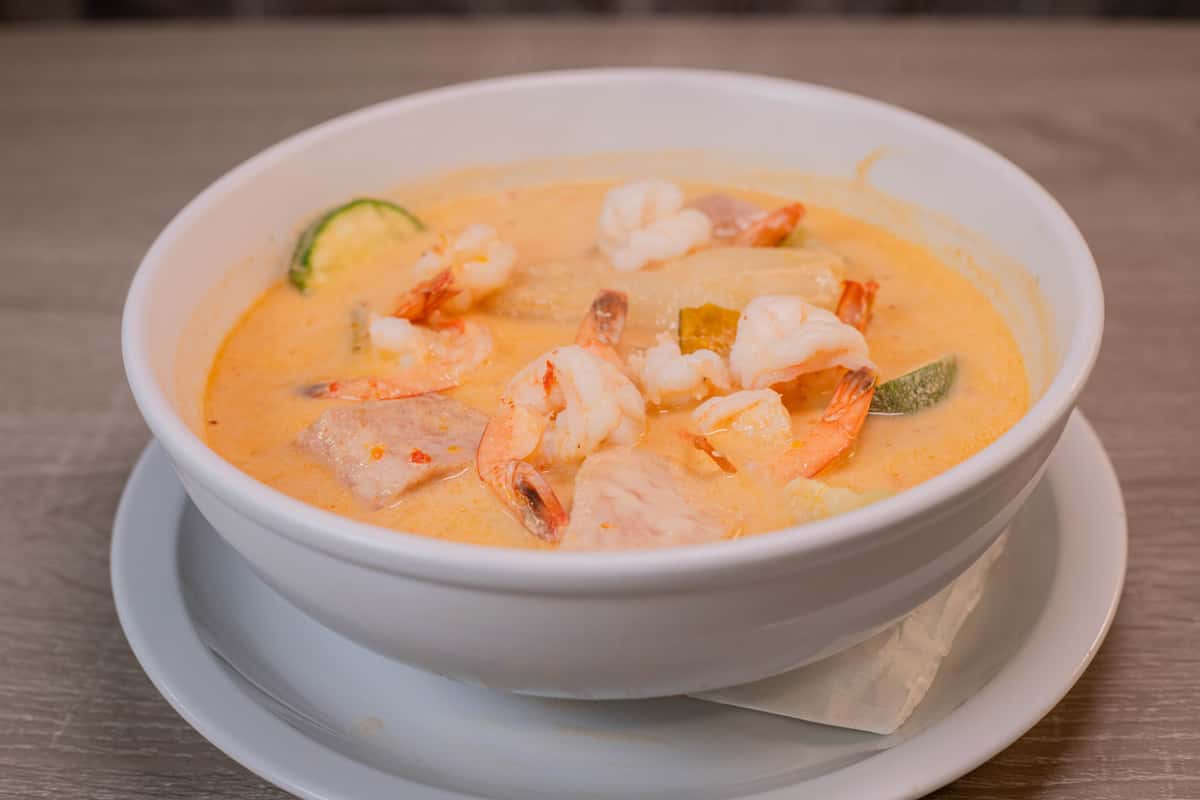 shrimp soup with coconut milk and vegetables, served with white rice onion and cilantro.