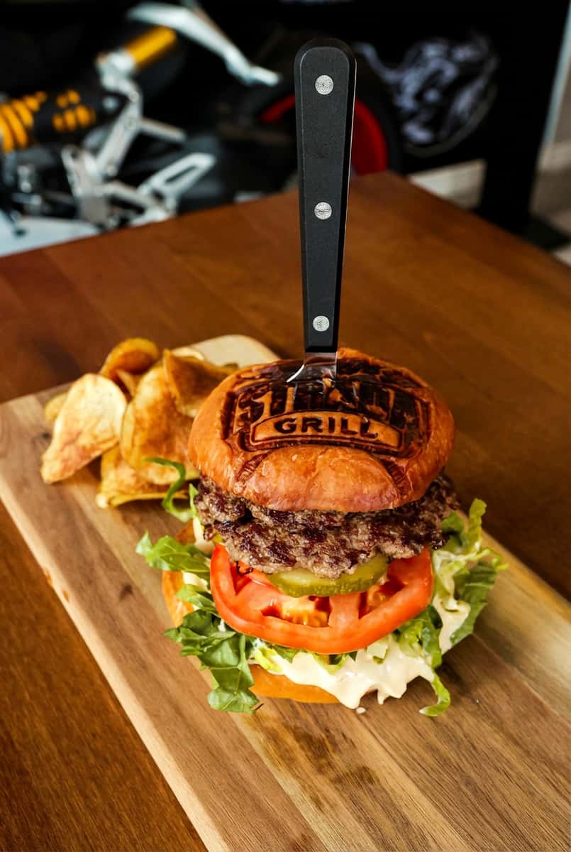 Fork placed through branded burger bun