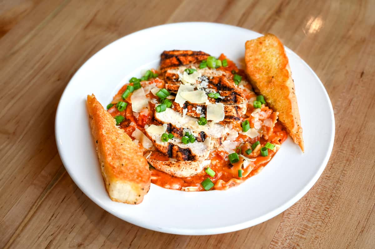 Farfalle pasta tossed with a creamy Rosa sauce with bell peppers, onions, andouille sausage and shrimp. Topped with parmesan cheese and served with a side of garlic bread.