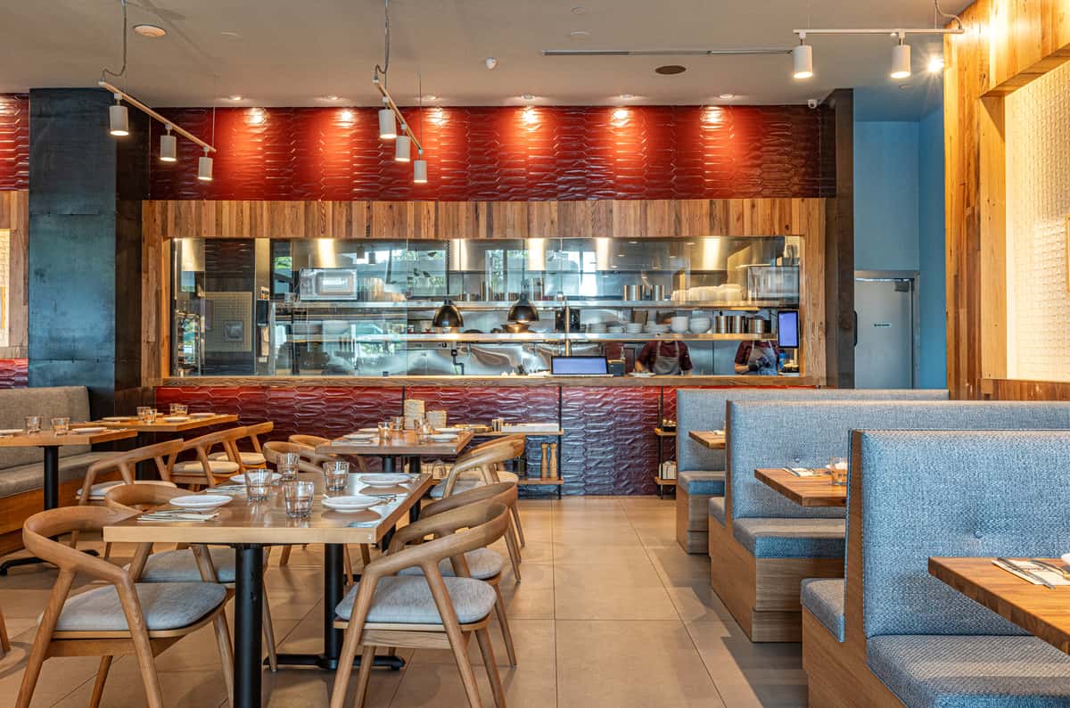 Open kitchen restaurant dining room with comfortable seating and chef-facing counter area.