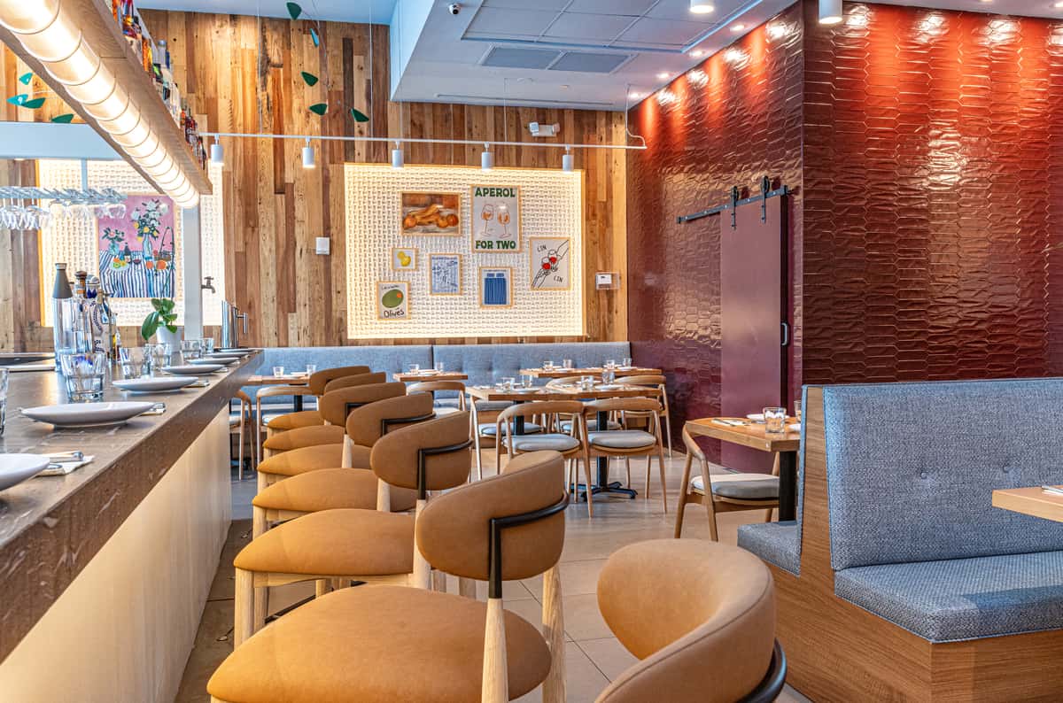 Stylish restaurant dining room with upholstered seating, wood-paneled walls, and elegant table settings.