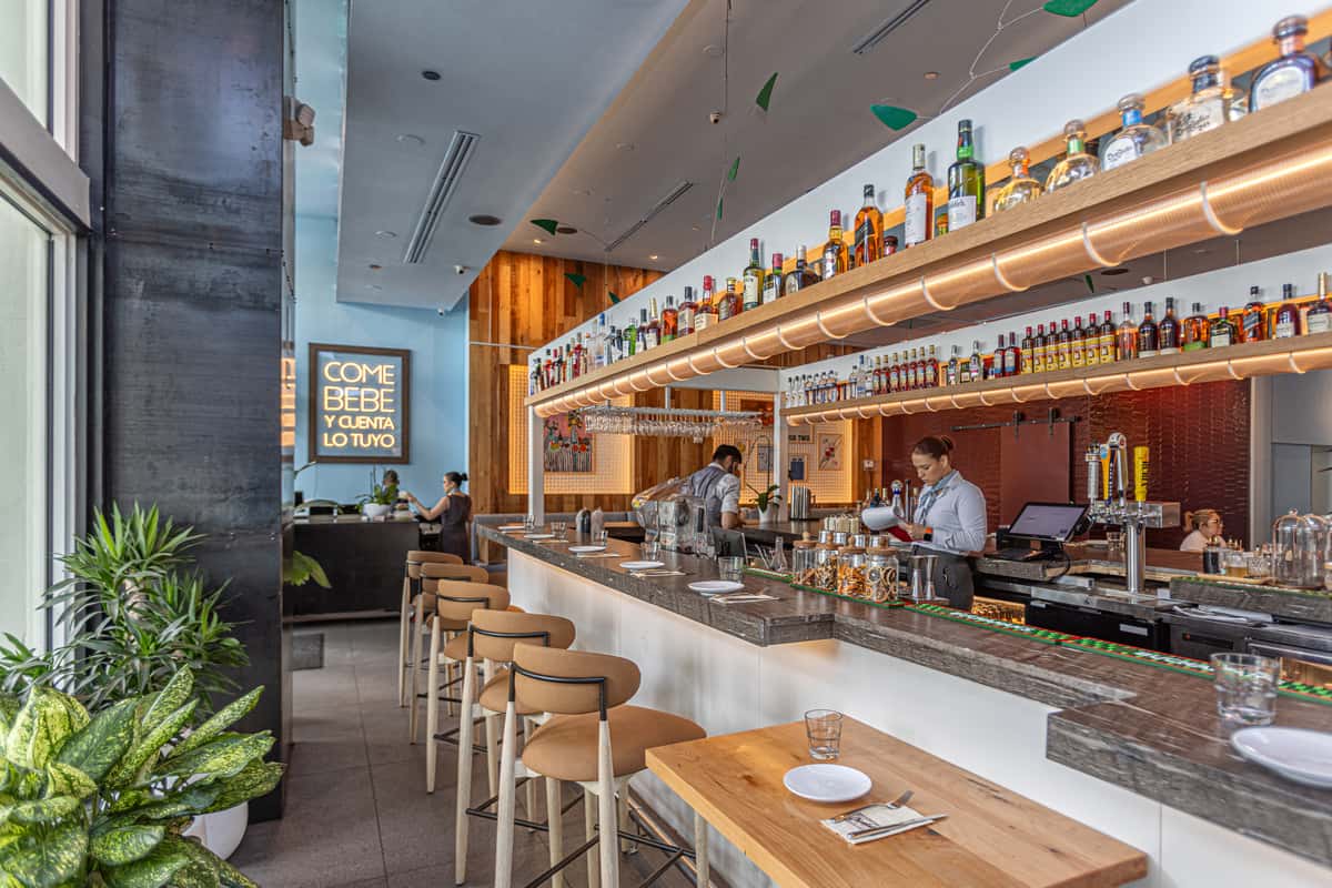 Elegant restaurant bar with marble countertops, high-top seating, and extensive liquor selection.