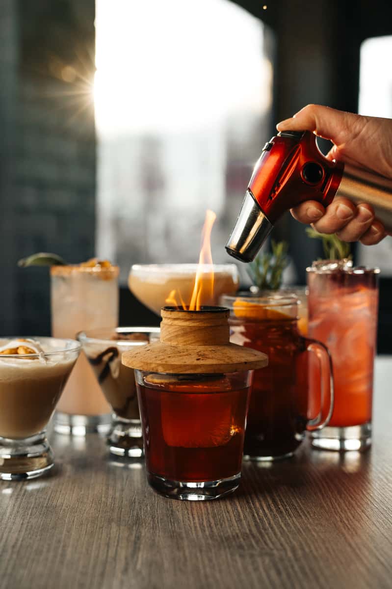 various craft cocktails in different glasses on the bar at Restaurant Coughlin's Law Kitchen and Alehouse in Mount Washington Pittsburgh; Seasonal Cocktail Menu