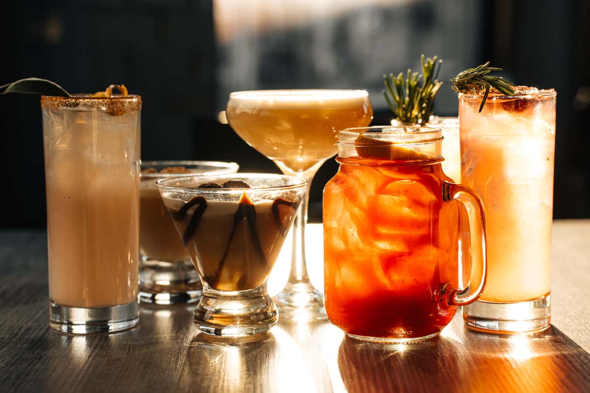 various craft cocktails in different glasses on the bar at Restaurant Coughlin's Law Kitchen and Alehouse in Mount Washington Pittsburgh; Seasonal Cocktail Menu