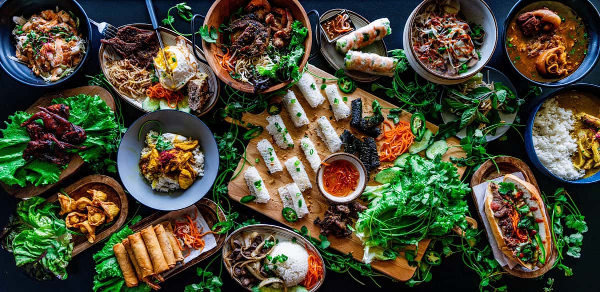 A large variety of Vietnamese food sprrad across a table