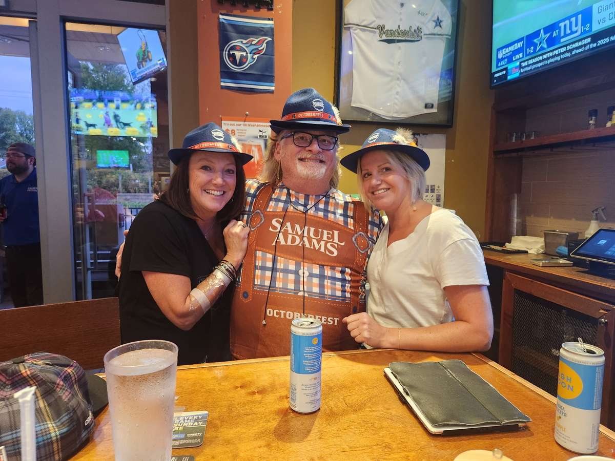 Three friends posing together at a restaurant table