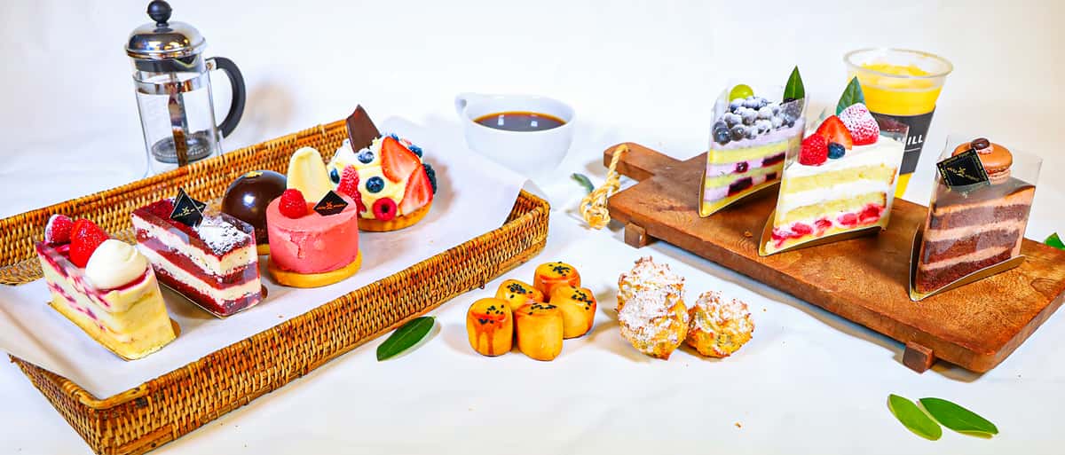 A wide display of assorted desserts arranged on trays and wooden boards.