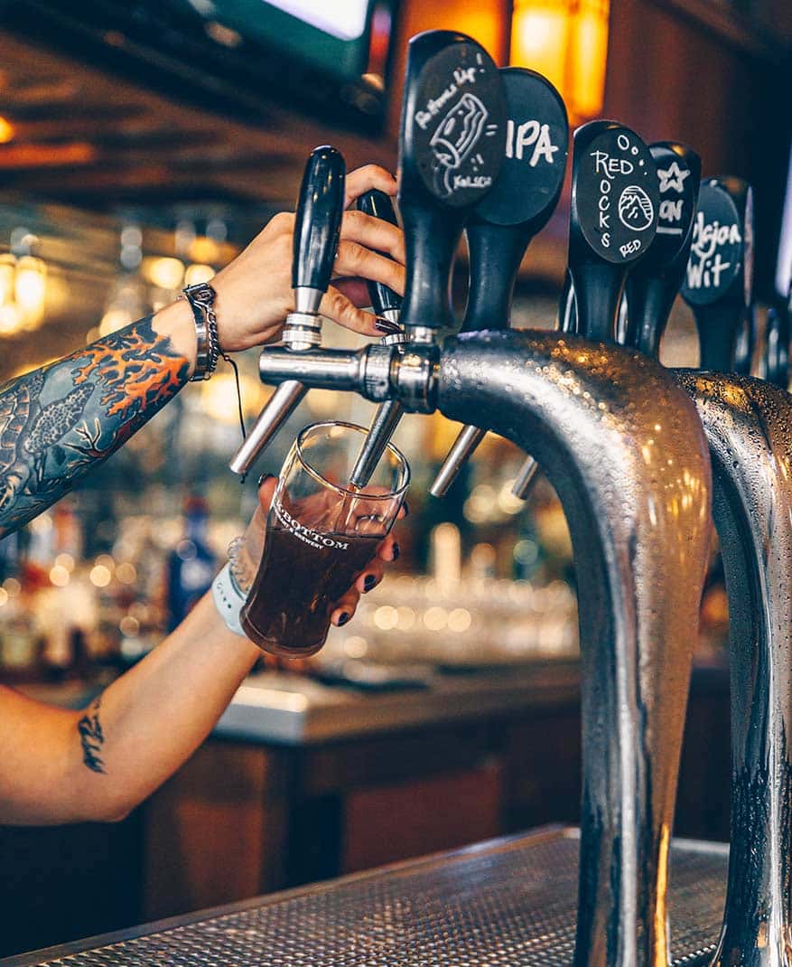 person pouring a pint of beer