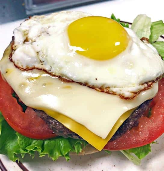 burger topped with lettuce, tomatoes, cheese and an egg