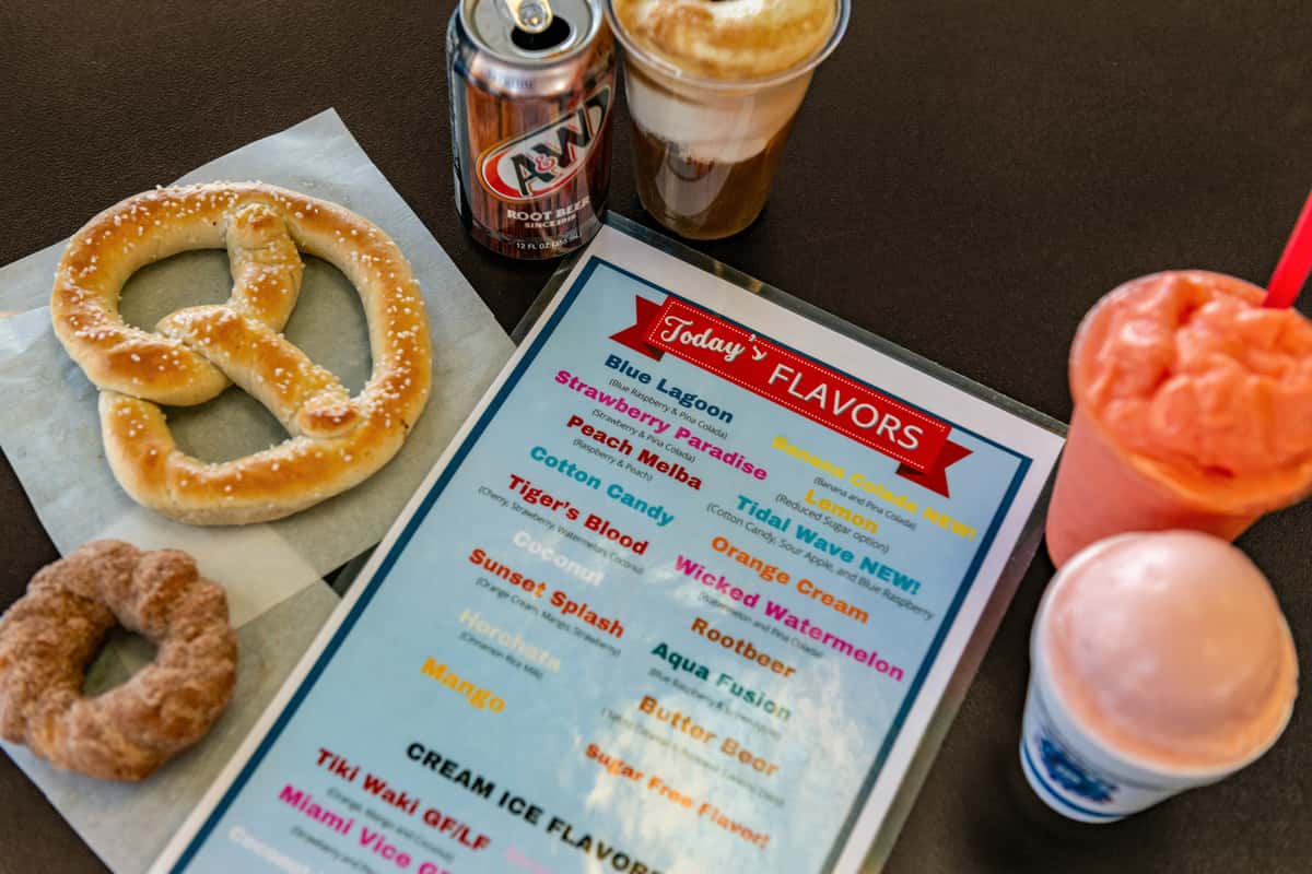 Menu on a table with a pretzel, drinks and frozen treats