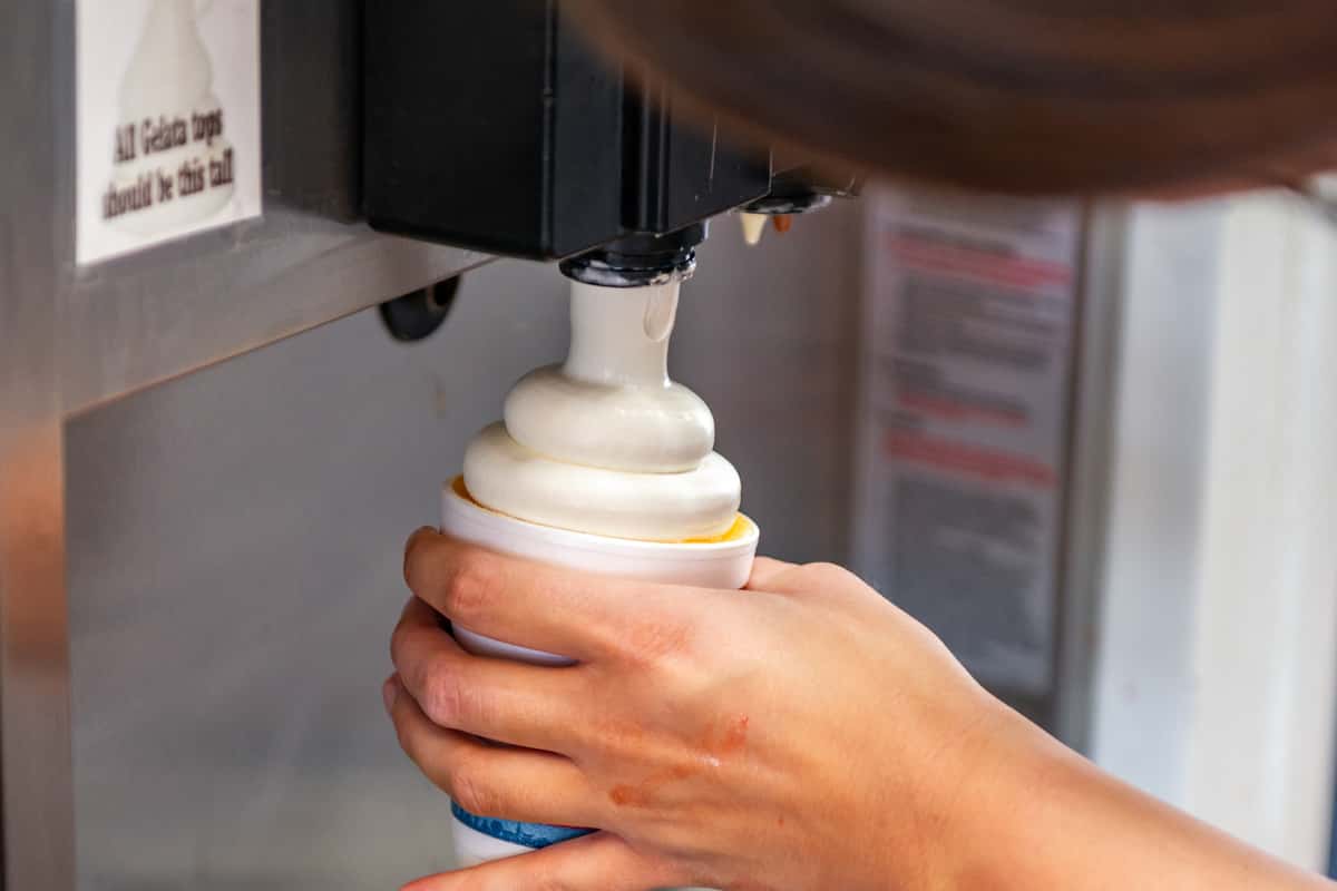 Hand swirling a cup of frozen custard