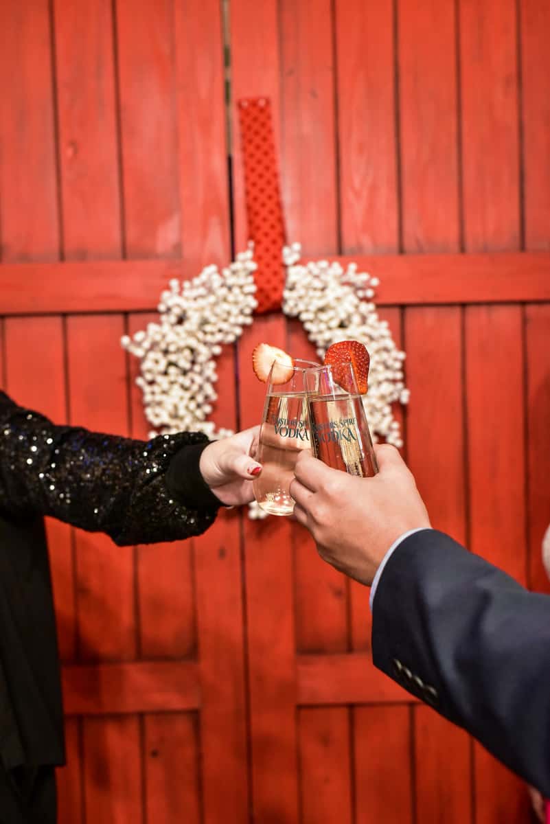 toasting in front of red barn door