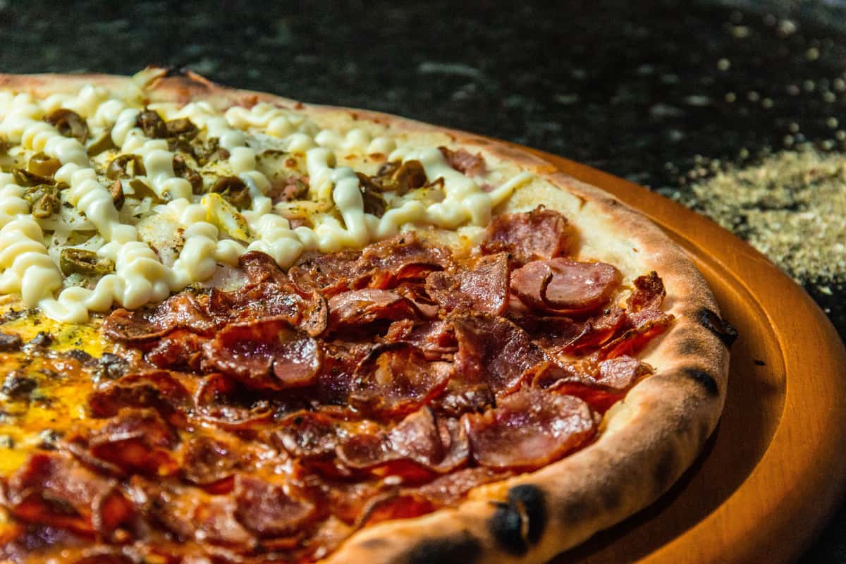 Specialty pizza topped with crispy pepperoni, sliced sausage, jalapeños, and a creamy cheese drizzle.