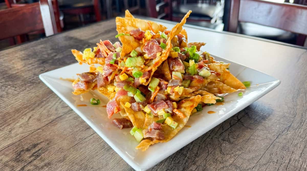Ahi tuna poke nachos with diced tuna, avocado, mango, and green onions on crispy wonton chips.