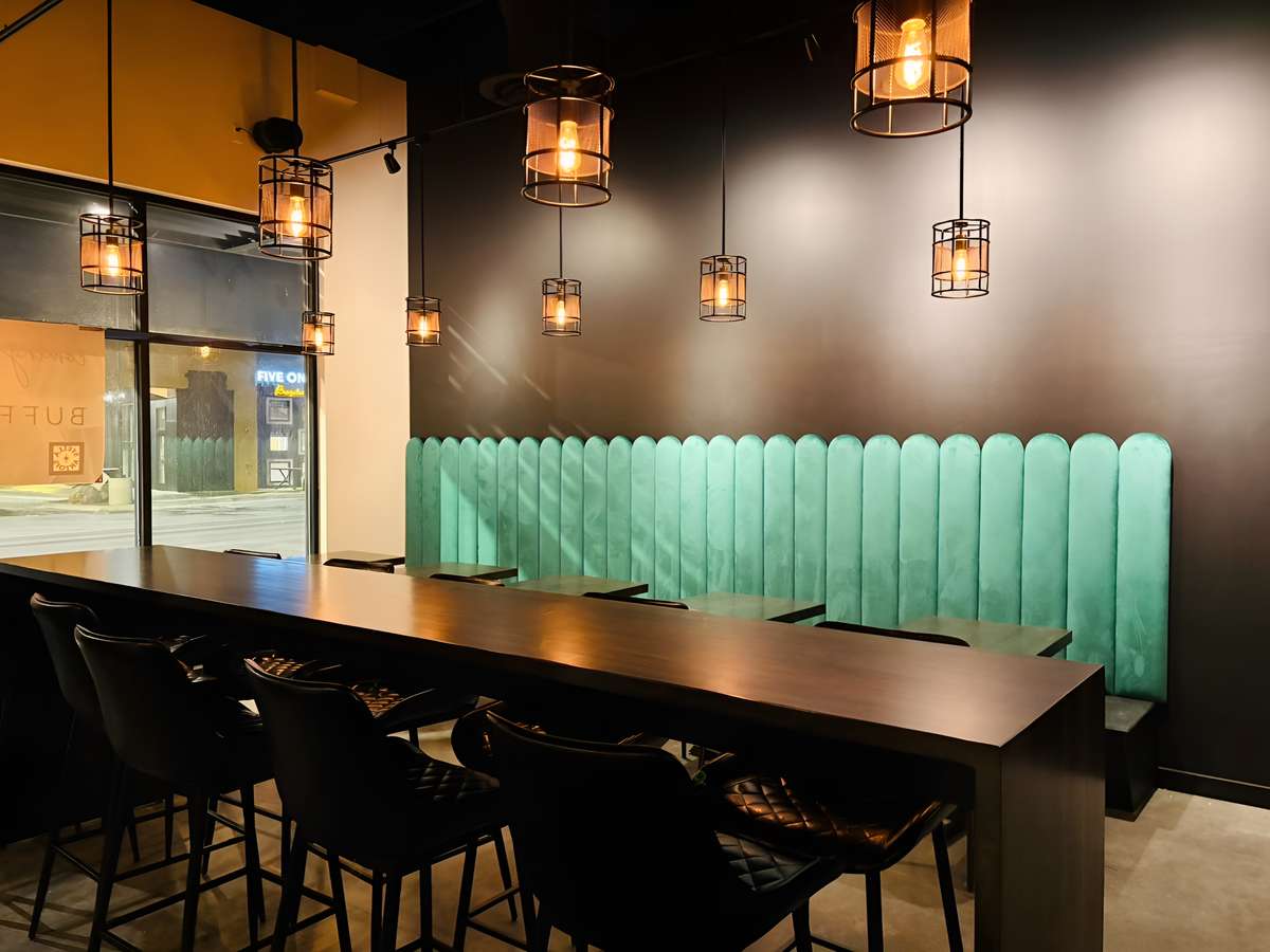 Modern dining room interior with a long table, bar seating, and pendant lights
